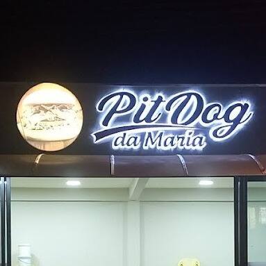 Letreiro Pit Dog da Maria aceso sobre a entrada da loja, na imagem pública do perfil no iFood.